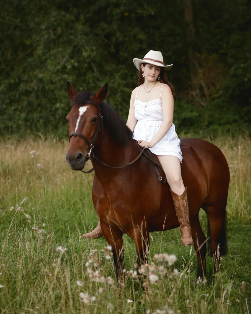Woman in white dress riding a brown horse