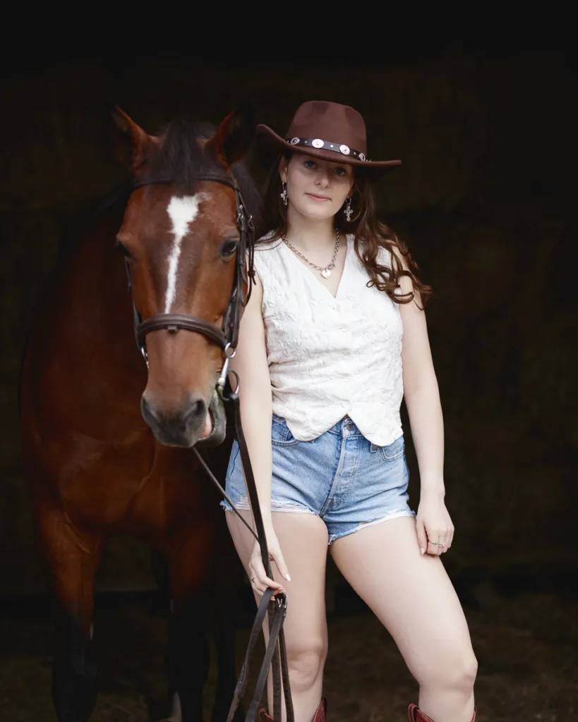 Woman with horse in cowboy attire.