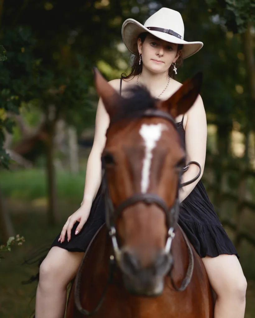 Person in cowboy hat riding horse