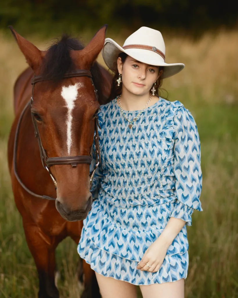 Woman in hat with horse in countryside