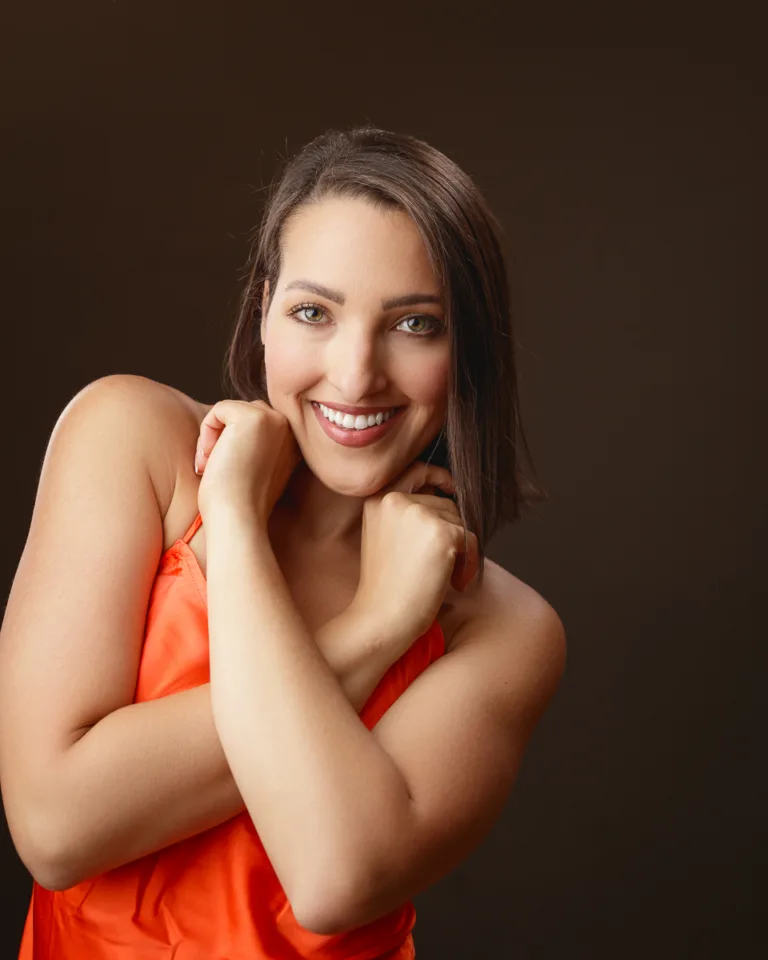 Woman in orange dress smiling warmly