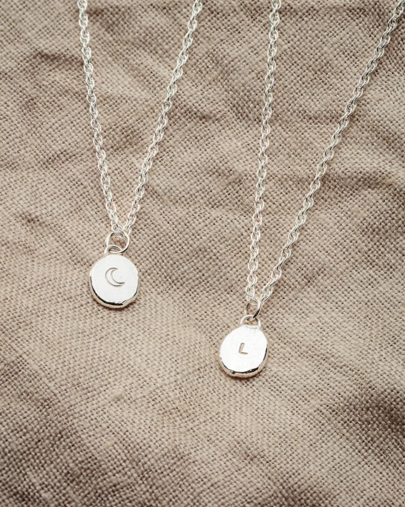 Silver necklaces with moon and letter pendants