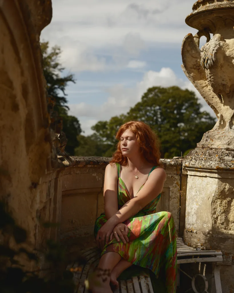 Woman in bright dress sitting outdoors.
