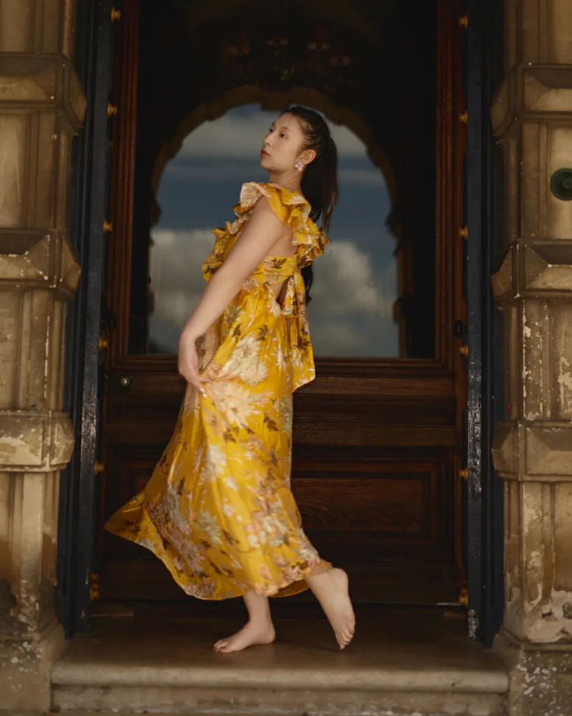 Woman in yellow dress posing in doorway.