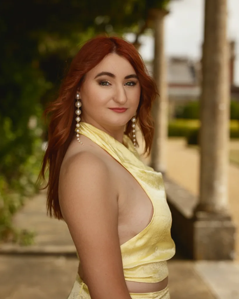 Person with red hair in yellow dress outdoors