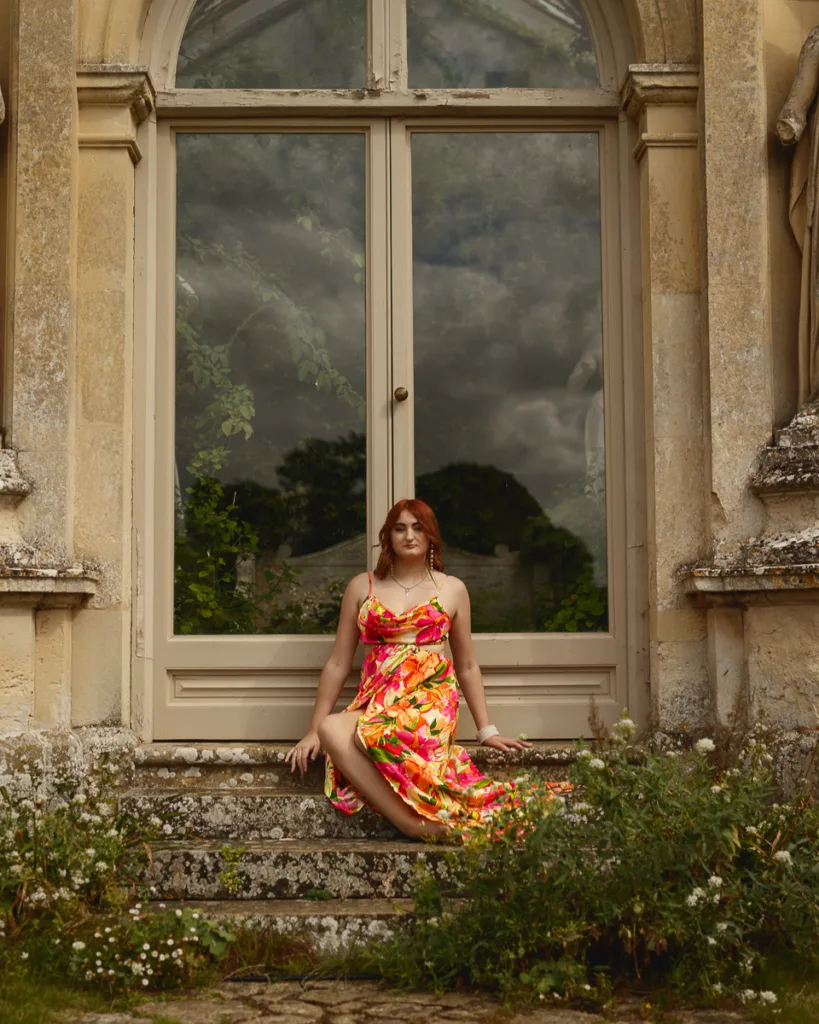 Woman in floral dress sitting on stone steps