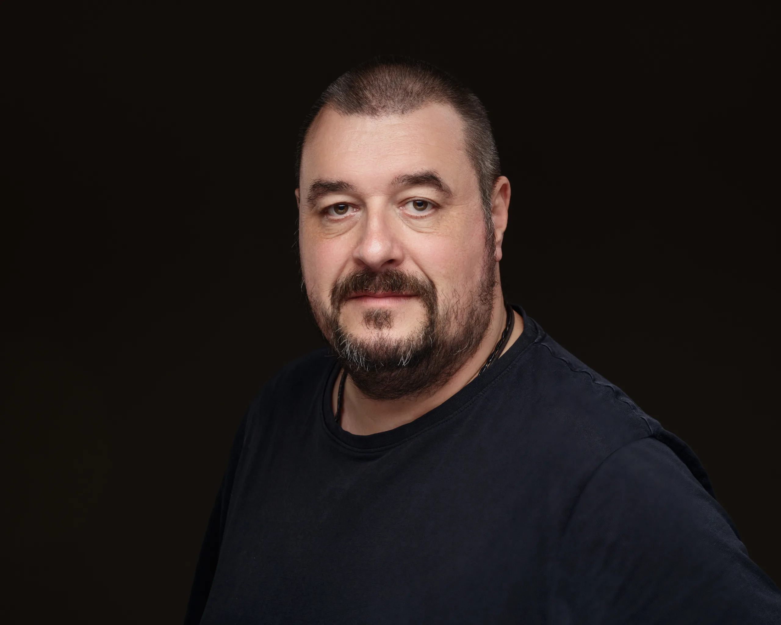 Man in dark shirt against plain background