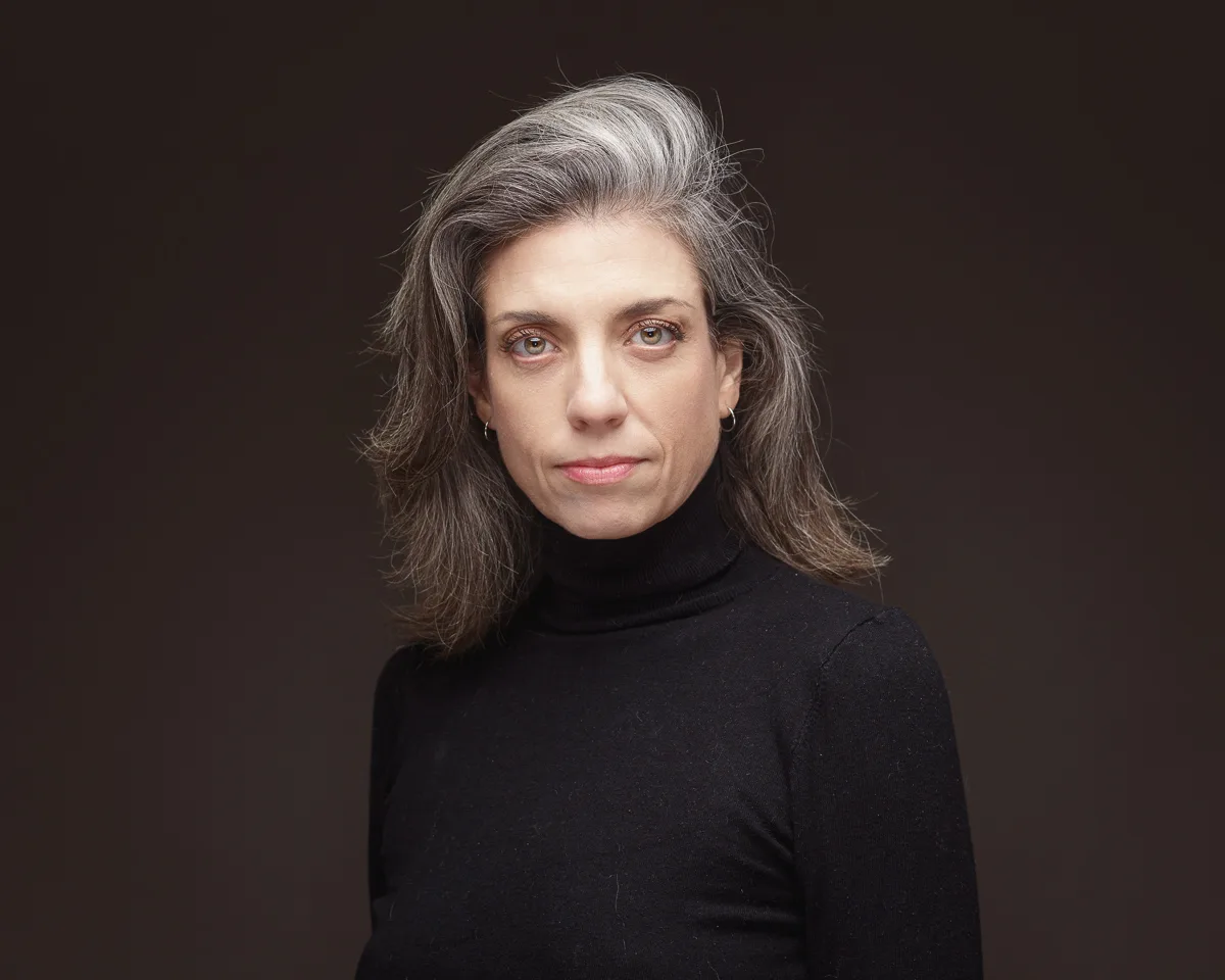 Woman in black turtleneck with grey hair