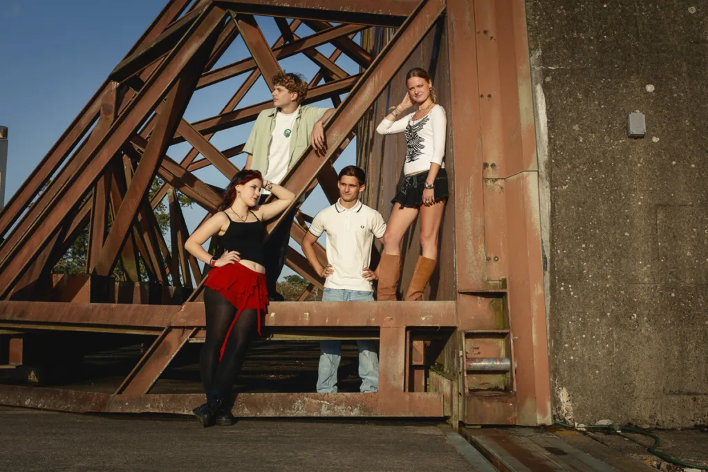 Group posing on industrial metal structure outdoors