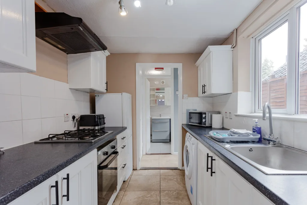 Modern kitchen with white cabinets and appliances.