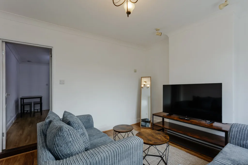 Modern lounge with grey sofa and large TV