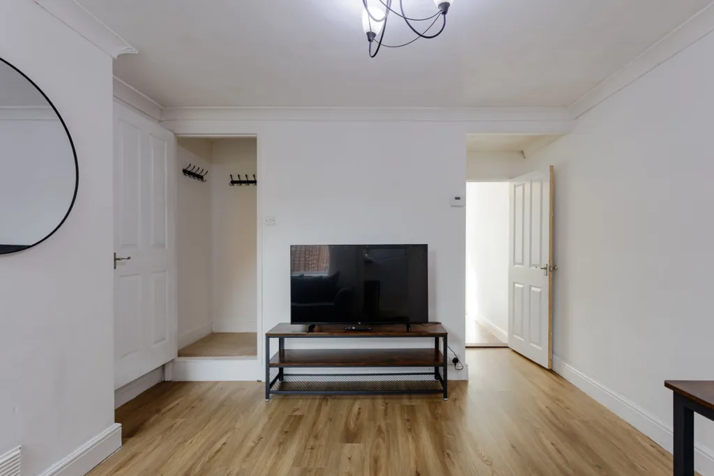 Minimalist living room with TV and hardwood floor.