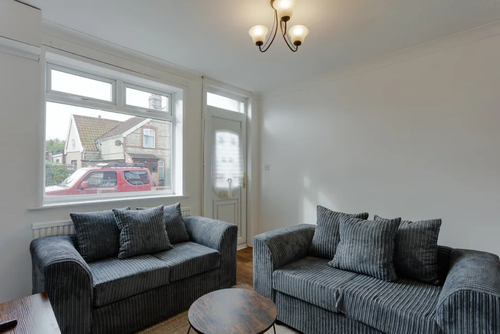 Modern living room with grey sofas and window view.