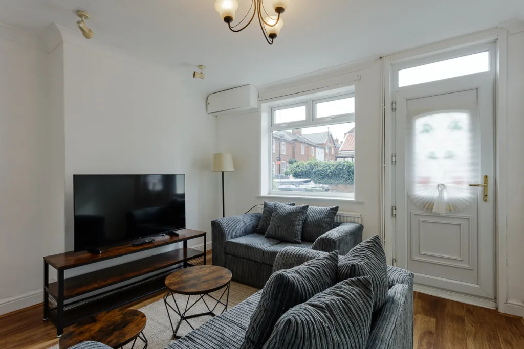 Modern living room with TV and grey sofas.