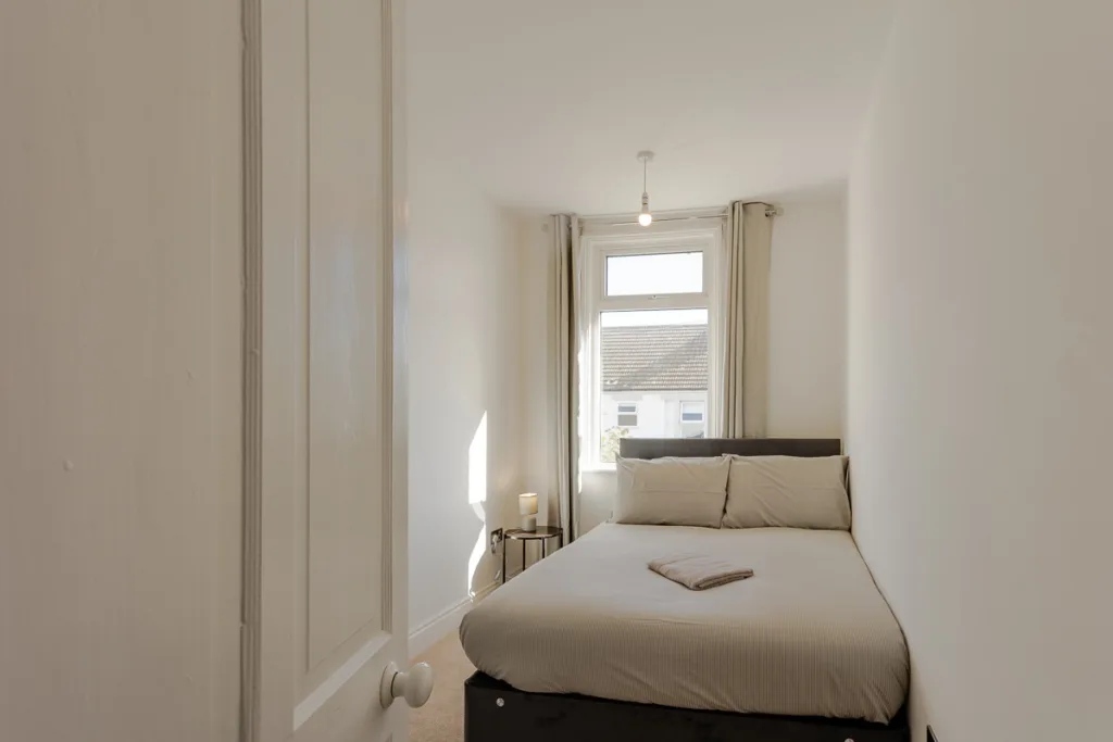 Small bedroom with double bed and window view.