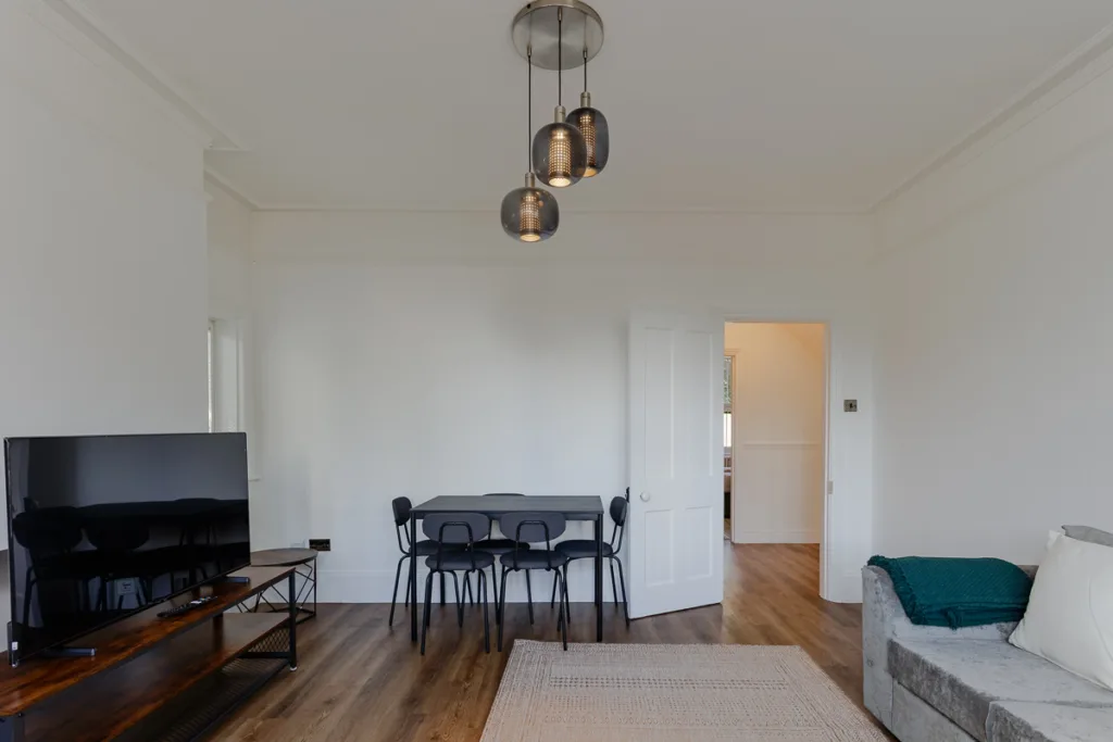 Modern living room with TV and dining table.