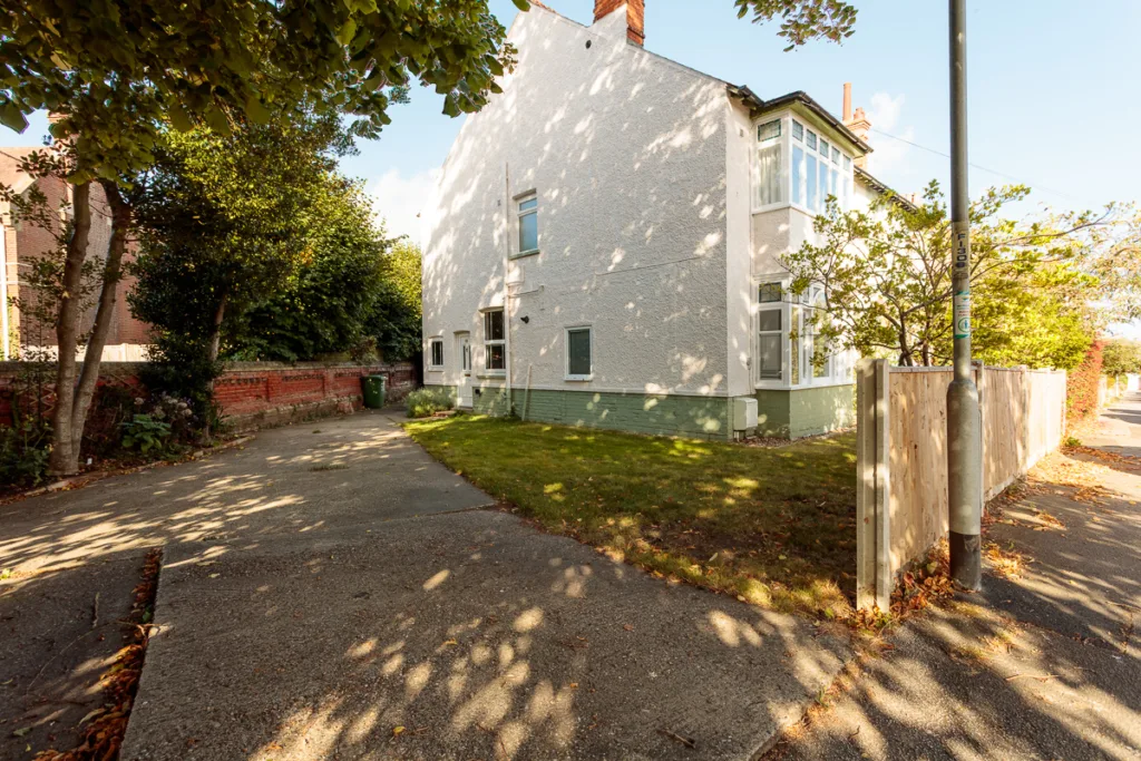 White house with driveway and garden