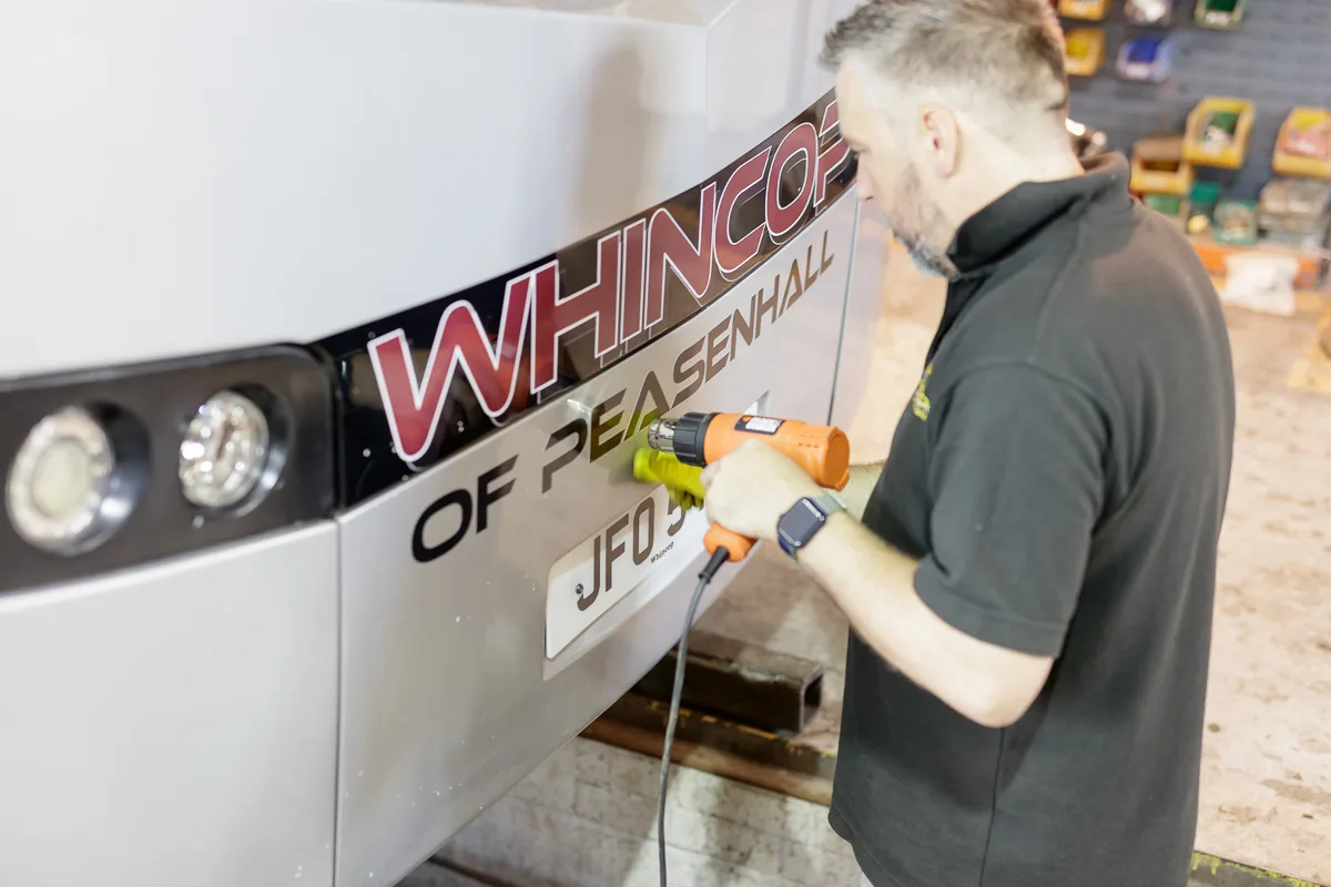 Sign fitter applying Whincop of Peasenhall lettering to a vehicle
