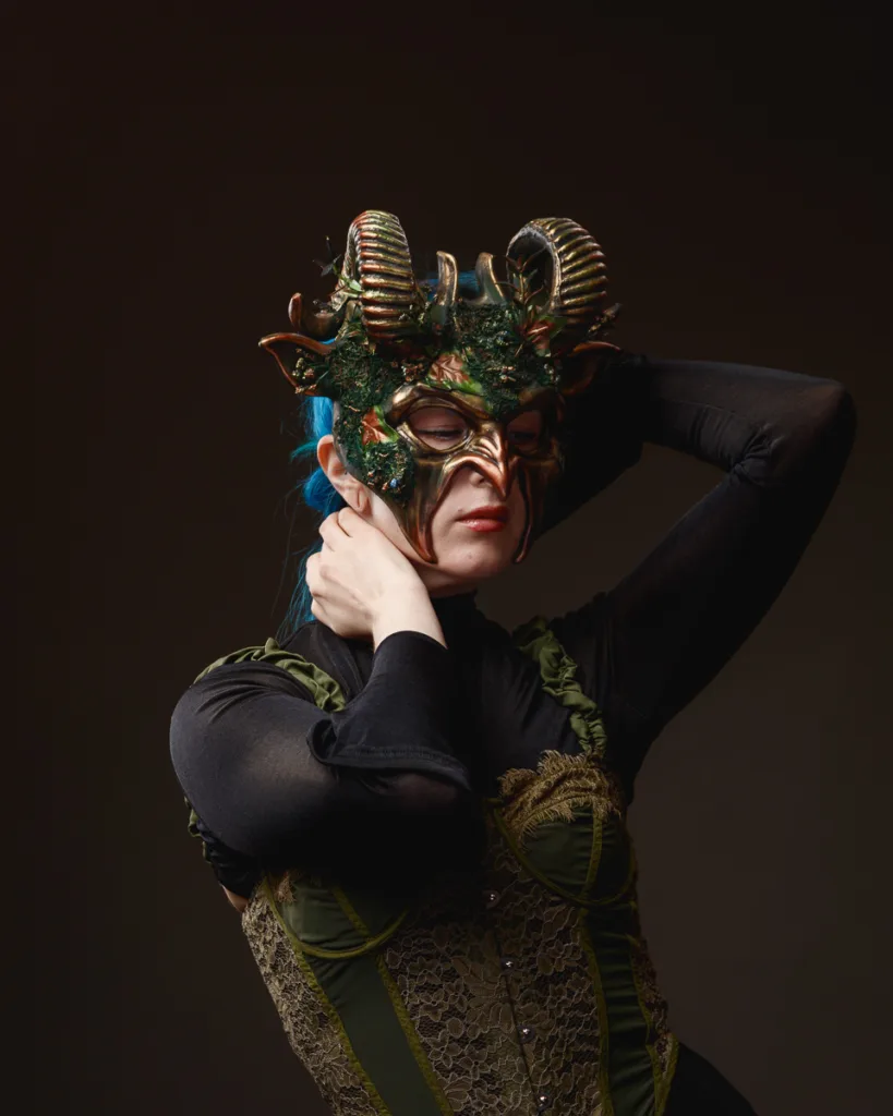 Woman in horned mask and green corset
