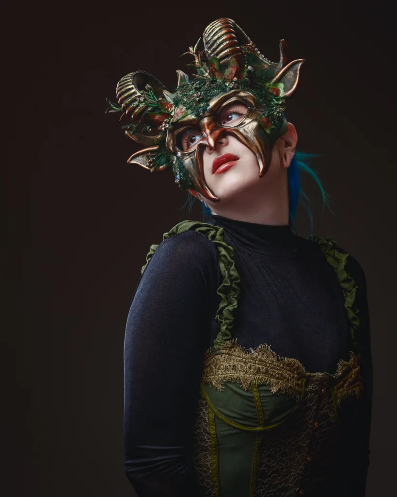 Person in ornate mask with horns and foliage