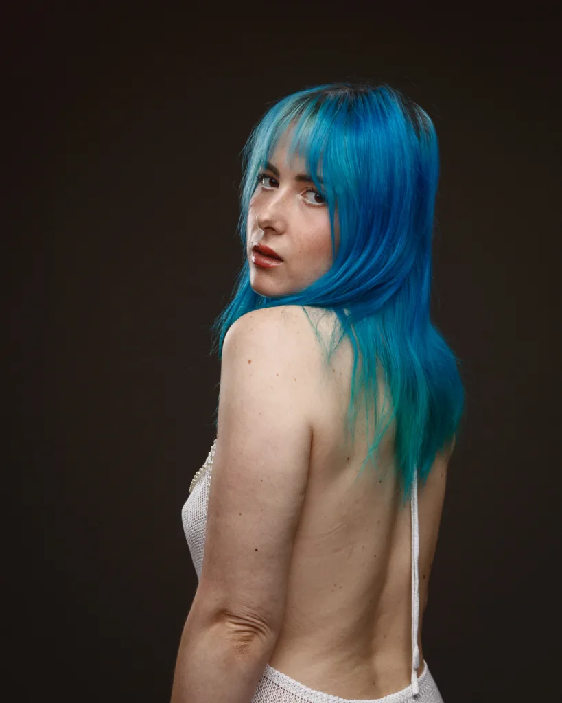 Person with vibrant blue hair facing backward