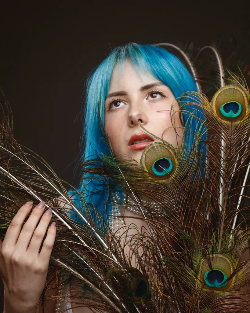 Woman with blue hair and peacock feathers