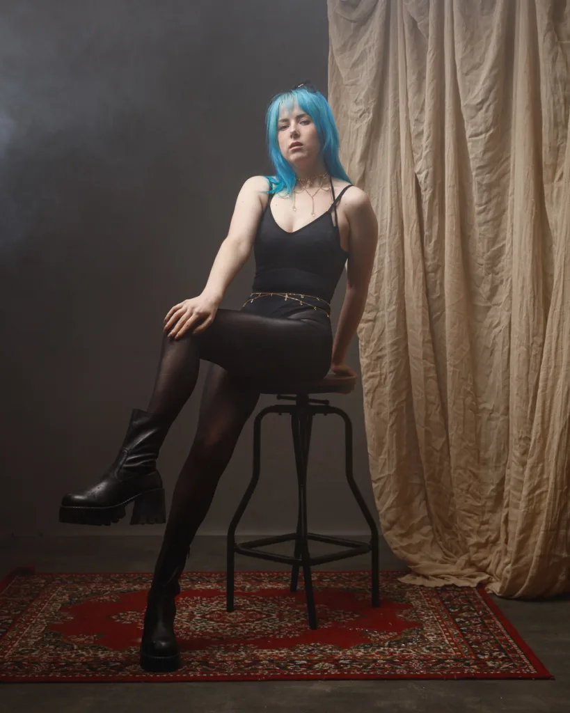 Person with blue hair in studio setting