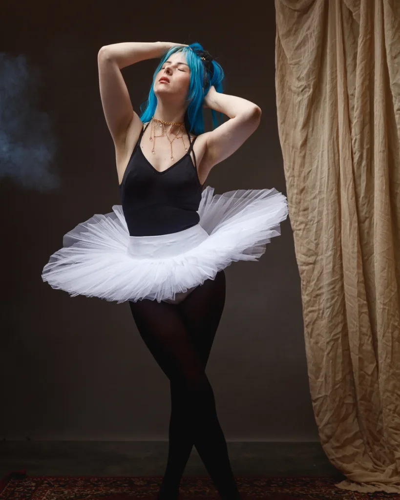Ballet dancer with blue hair in tutu posing.