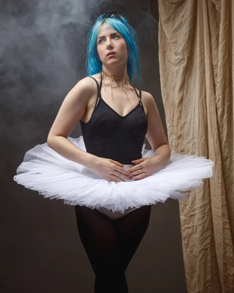 Ballet dancer with blue hair in tutu pose.