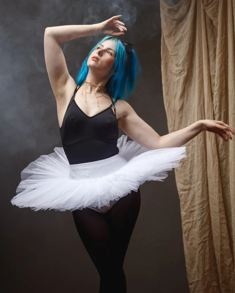 Ballet dancer in tutu with vibrant blue hair.