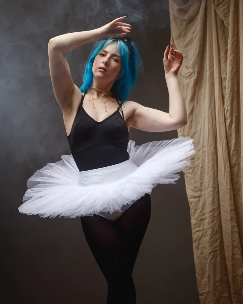 Ballet dancer with blue hair in costume.