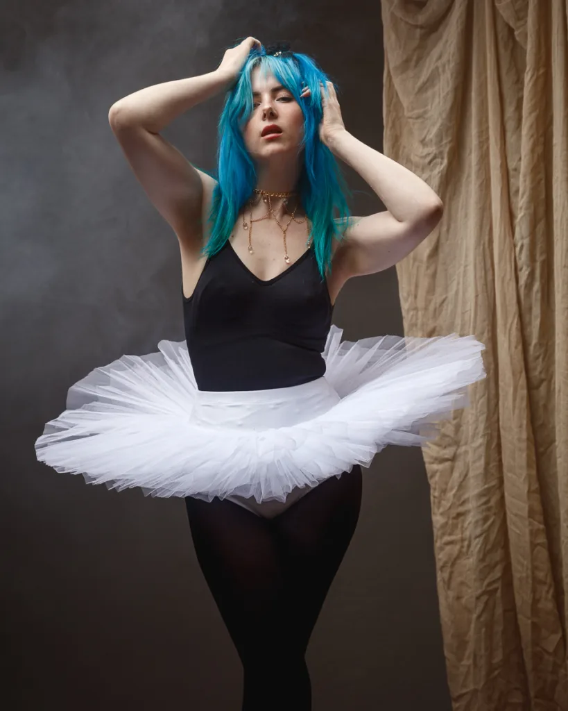 Woman in tutu poses confidently indoors.
