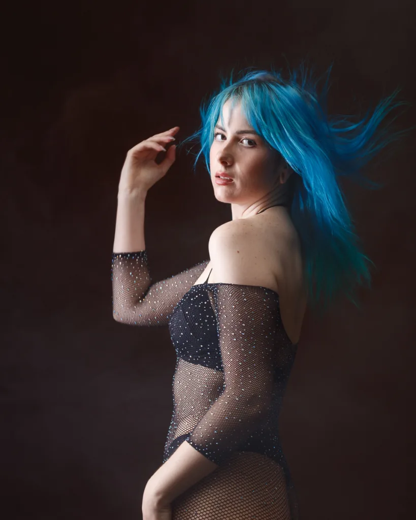 Person with blue hair in sparkly outfit posing.