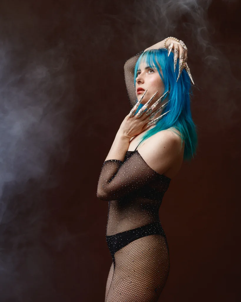 Woman with blue hair and silver claw nails.