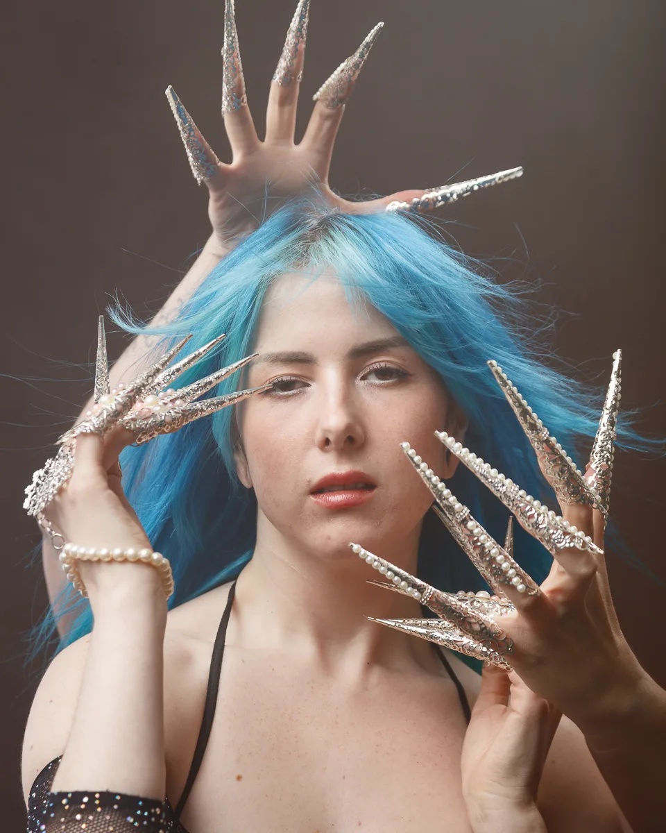 Woman with blue hair, ornamental silver nails.
