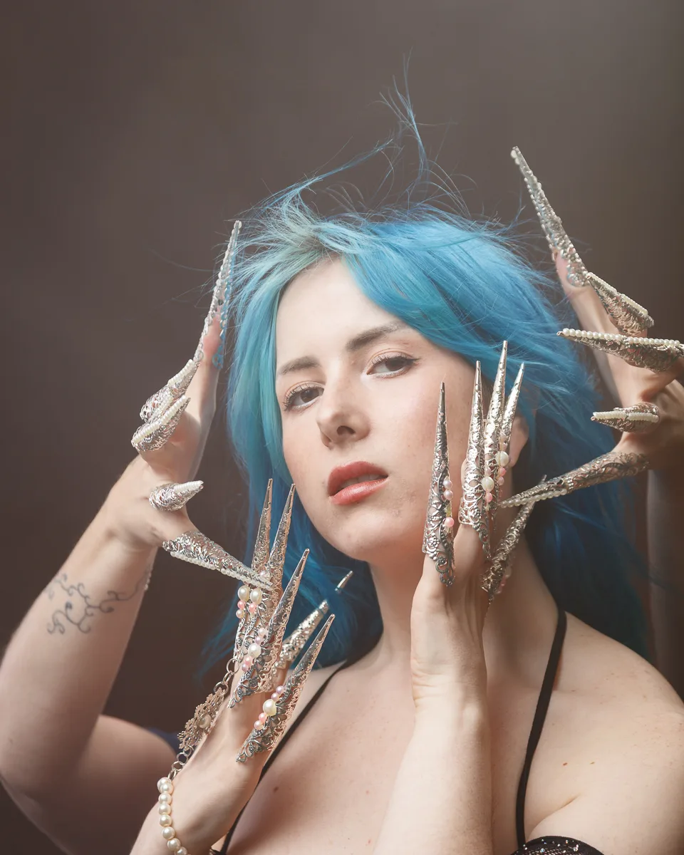 Woman with blue hair, ornate claw embellishments