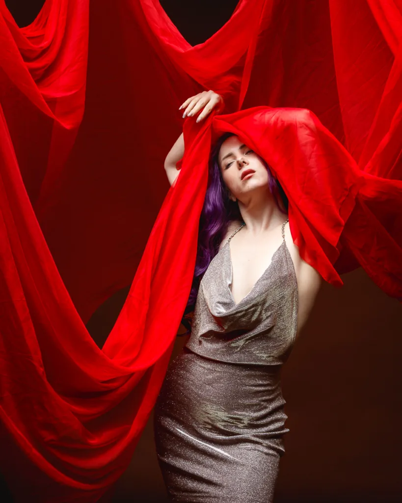 Woman in silver dress with red fabric