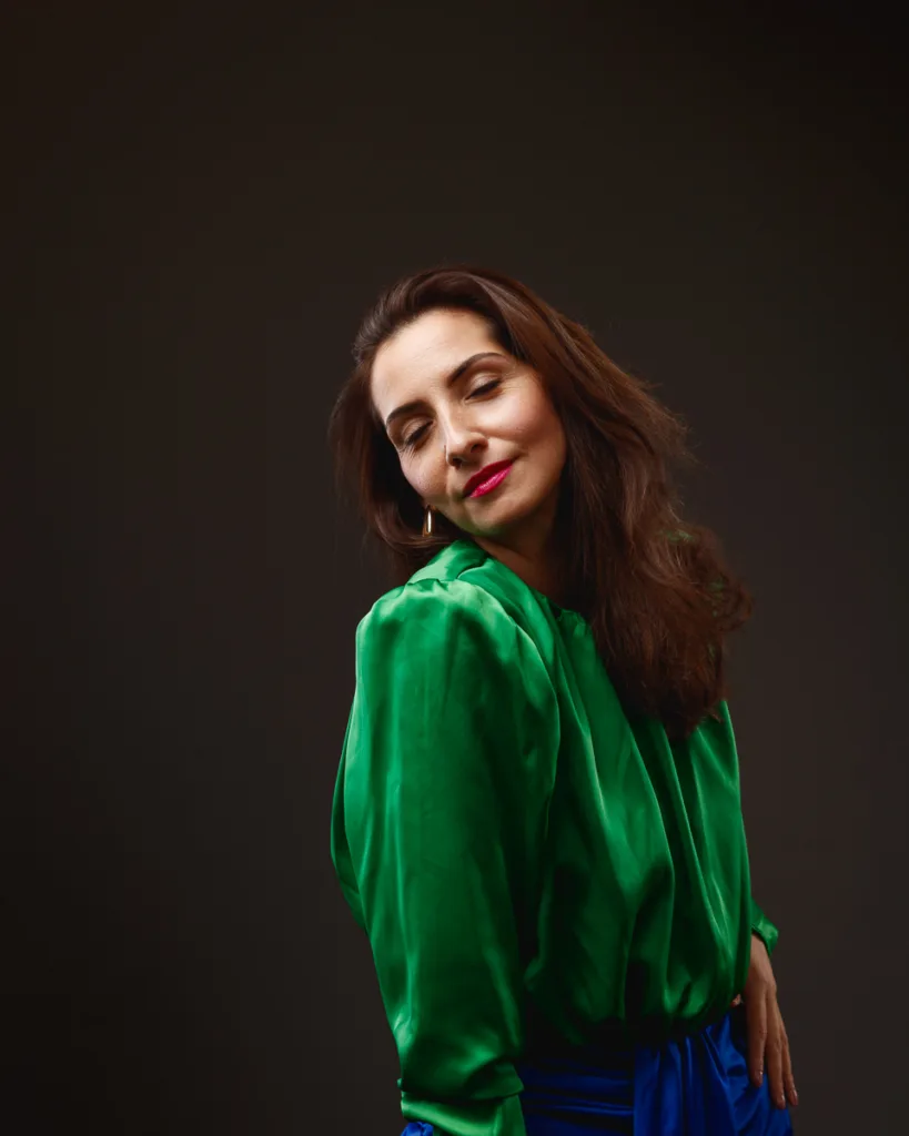 Woman in green blouse posing confidently