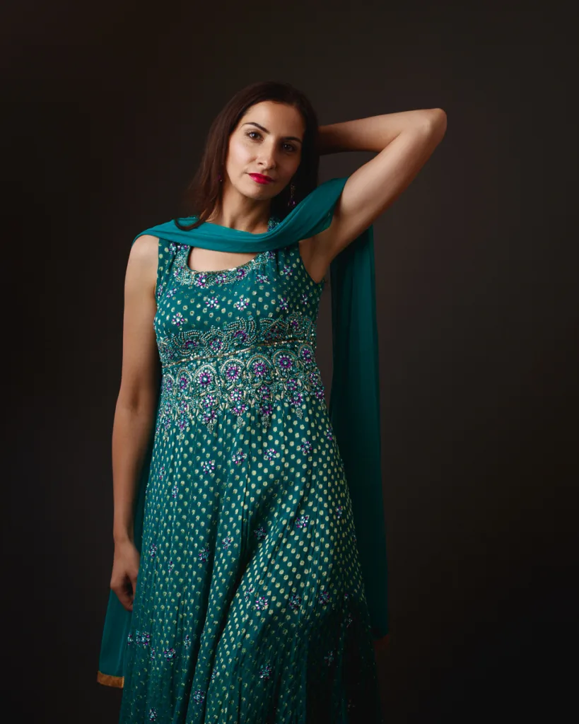 Woman in green ethnic dress posing gracefully