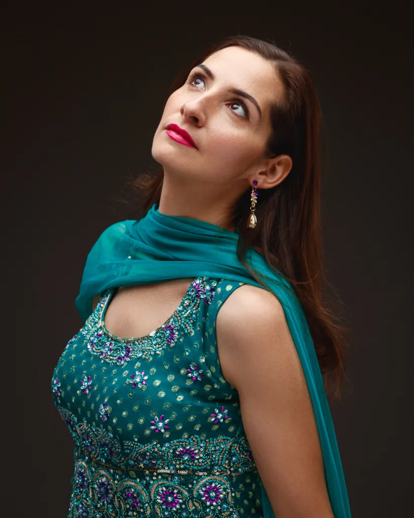 Woman in embroidered dress looking upwards.