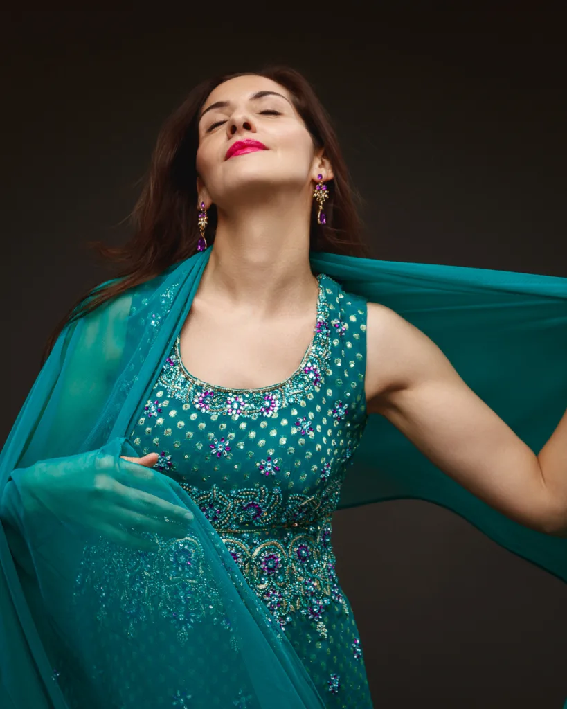 Woman in turquoise traditional dress with shawl.