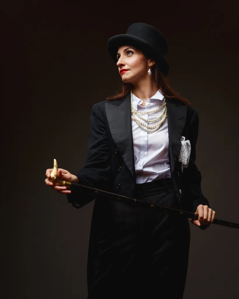 Woman in top hat with cane and pearls