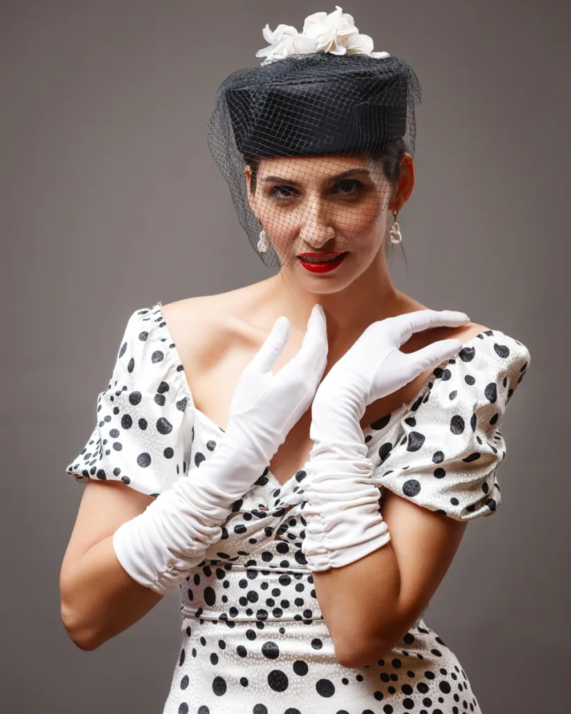 Woman in polka dot dress and vintage hat.