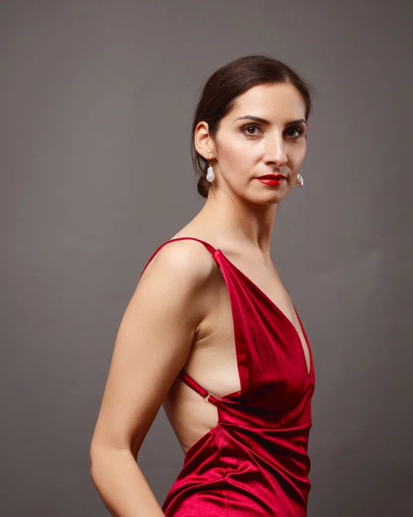 Woman in elegant red evening dress posing
