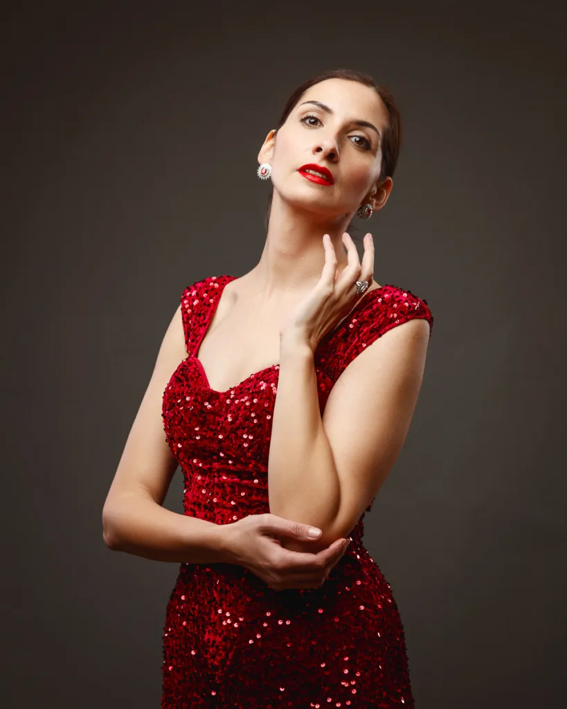 Woman in red sequin dress posing elegantly.