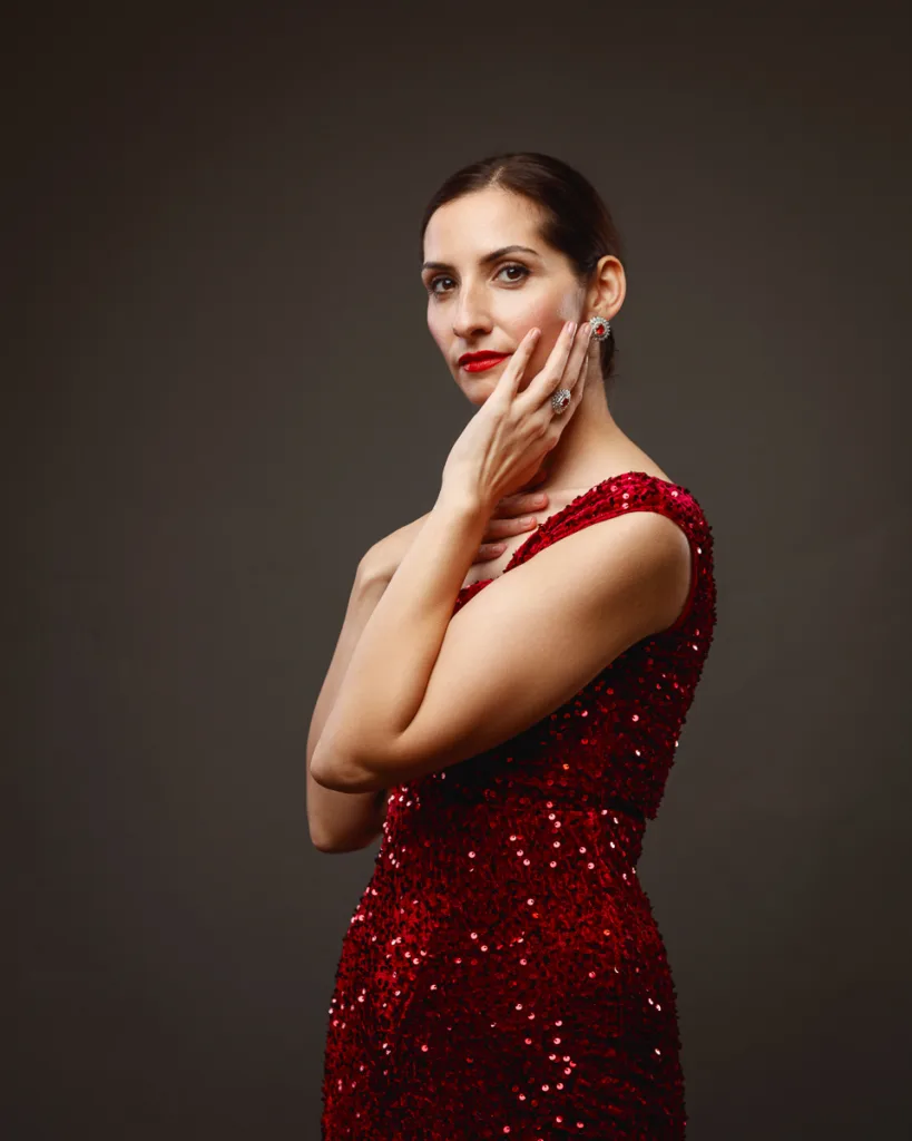 Woman in red sequin dress posing elegantly.