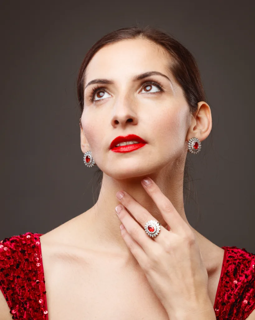 Woman in red dress with matching jewellery.