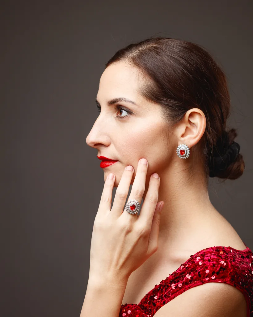 Elegant woman wearing red dress and jewellery.