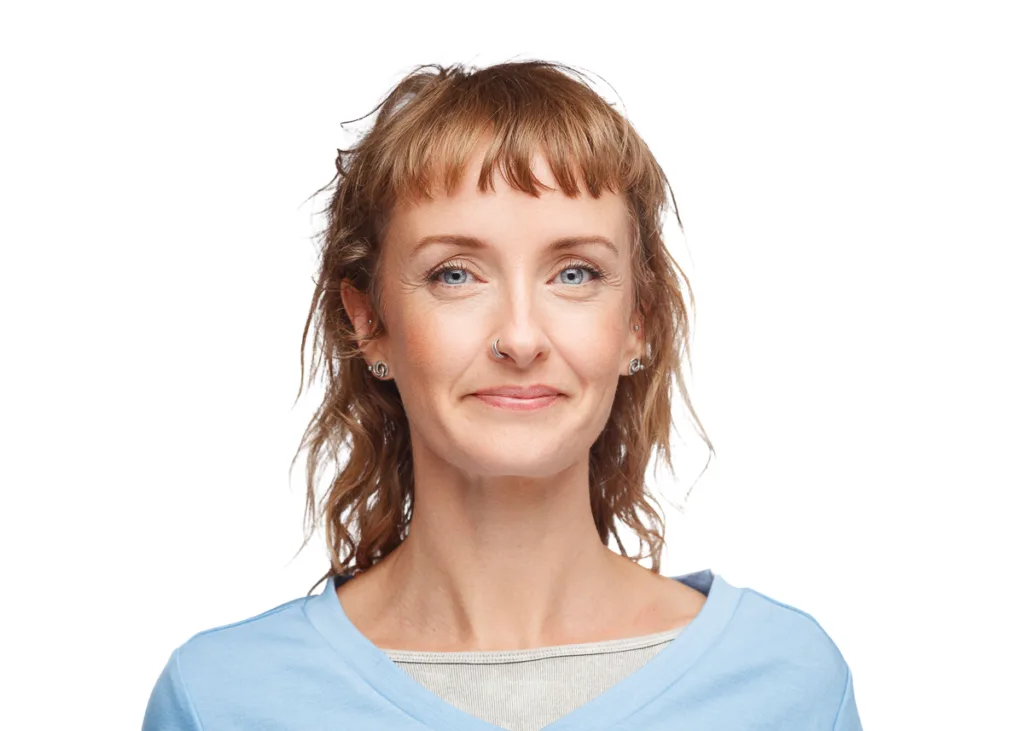 Smiling woman with a nose ring and earrings.