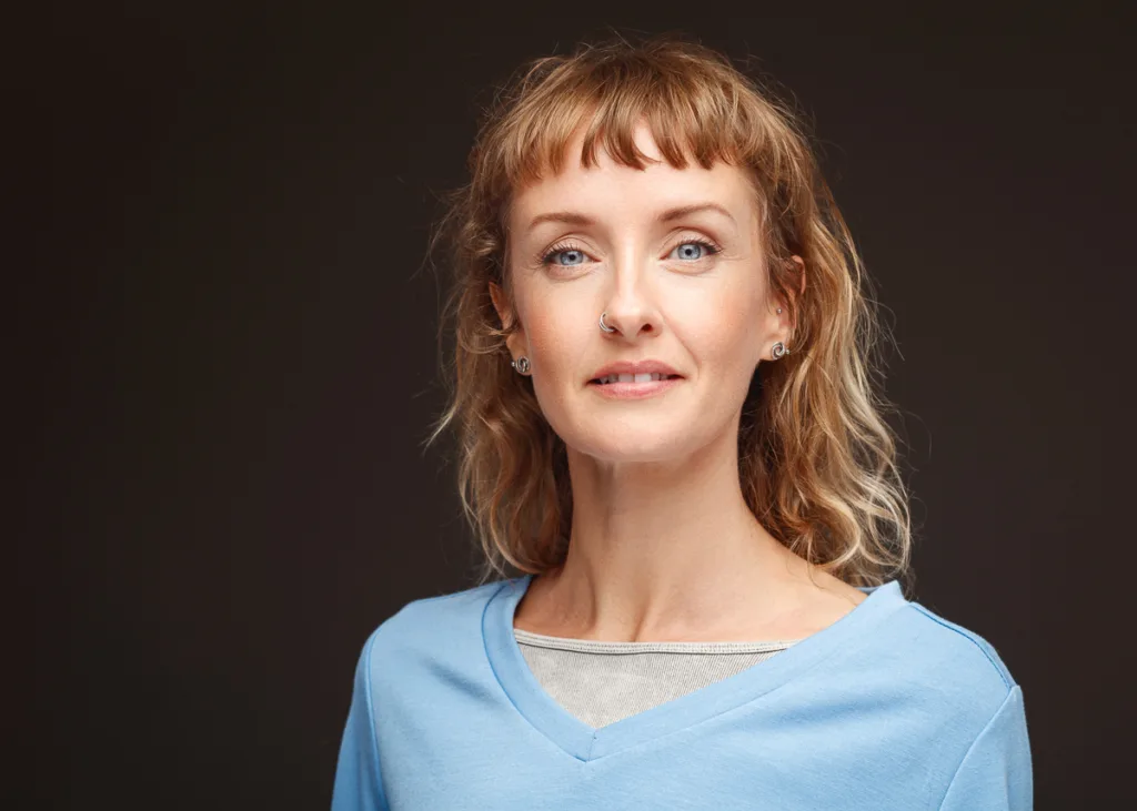 Smiling woman with curly hair and blue top